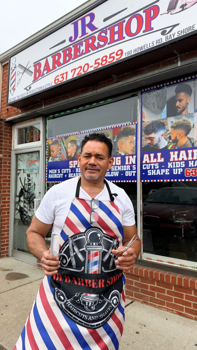 Jose, owner of JR Barbershop, outside the shop